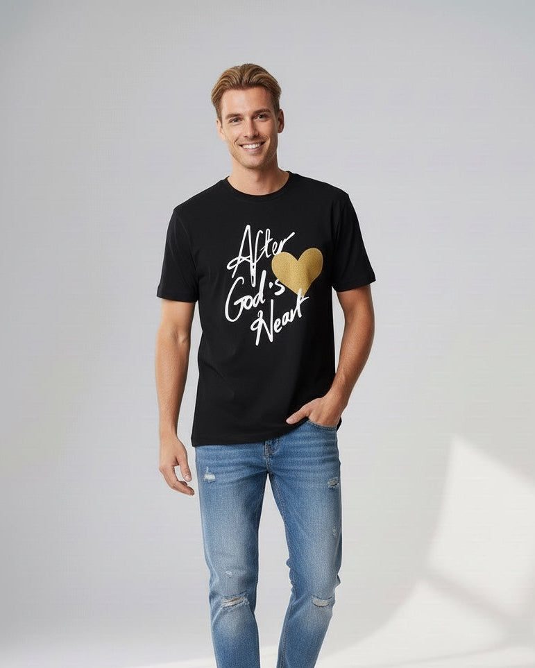 Man wearing a black t-shirt with text and a gold heart graphic, standing against a plain background