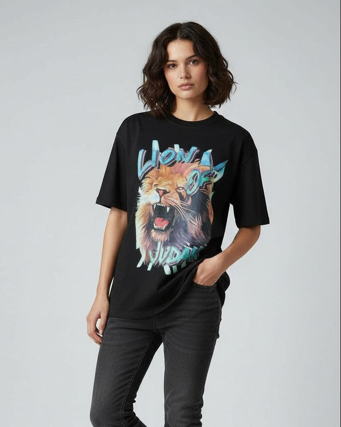 Person wearing a black christian t-shirt with a colorful lion graphic design on a plain background