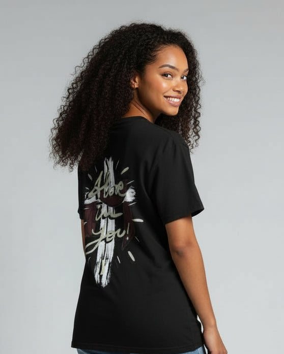 Woman wearing a black t-shirt with a graphic design and blue jeans on a gray background