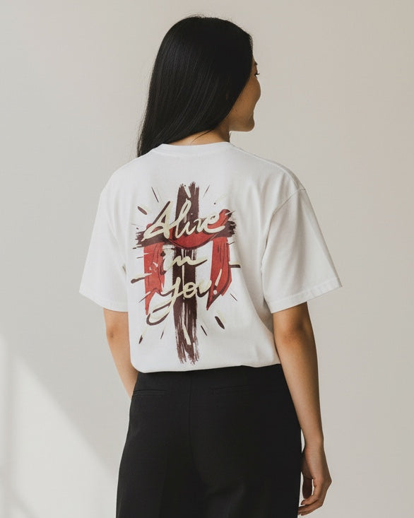 Person wearing a white t-shirt with graphic design and black pants on a light background