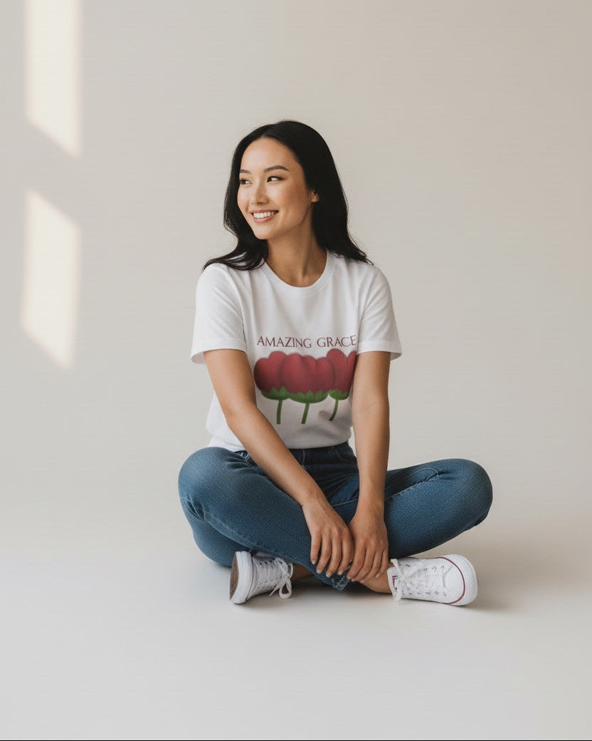 Person wearing a white t-shirt with a graphic design sitting on the floor.
