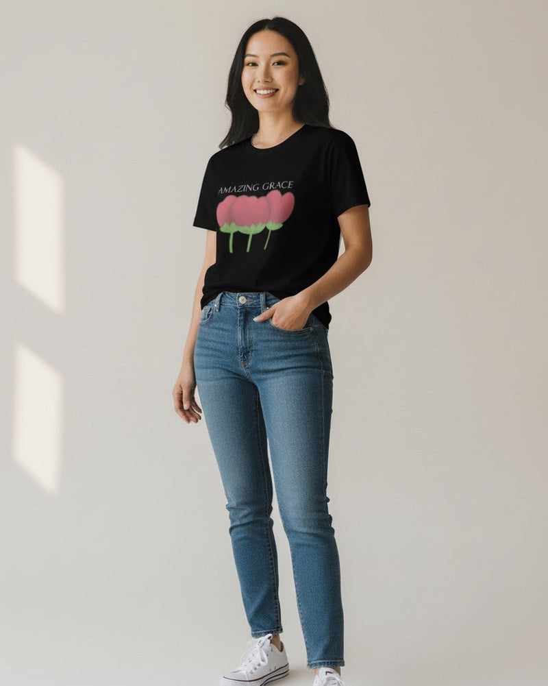 Woman wearing a black t-shirt with a graphic design and blue jeans on a plain background