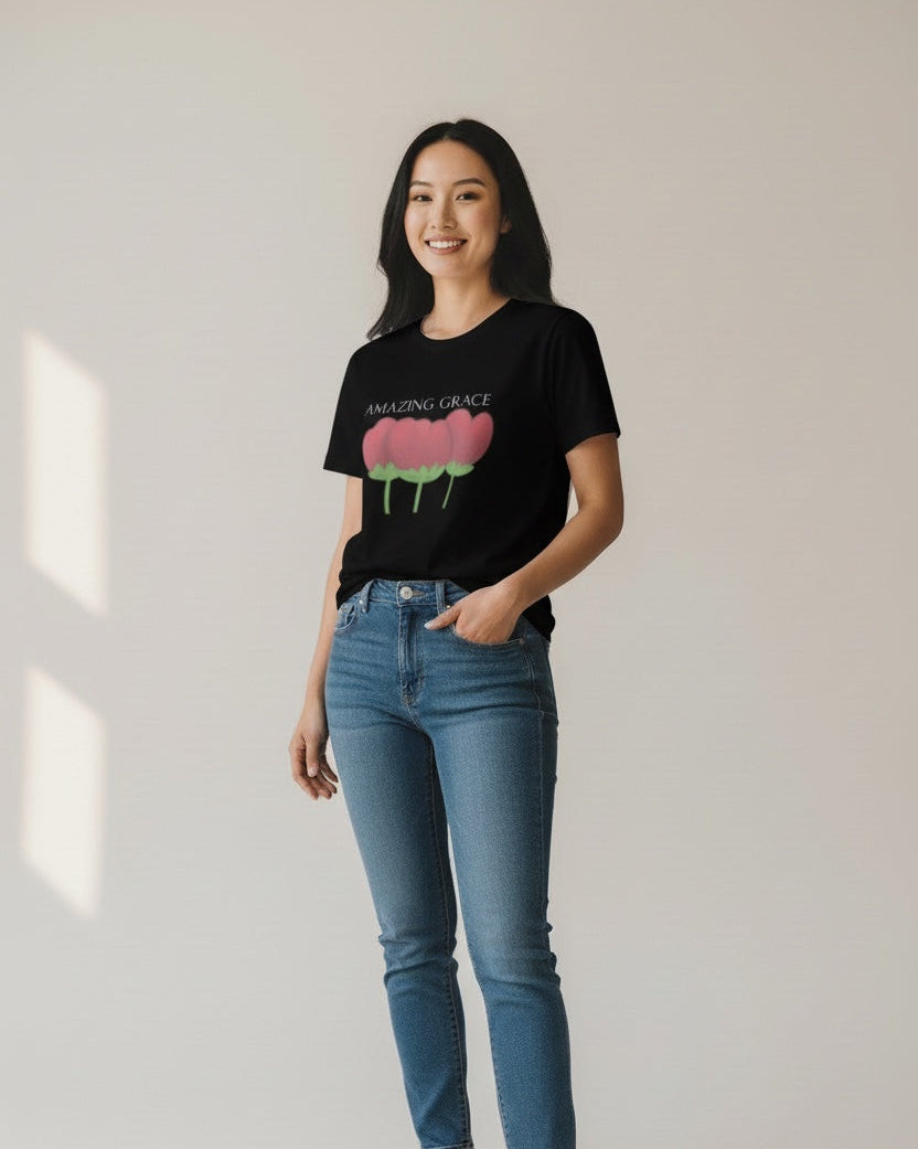 Woman wearing a black t-shirt with a graphic design and blue jeans on a plain background