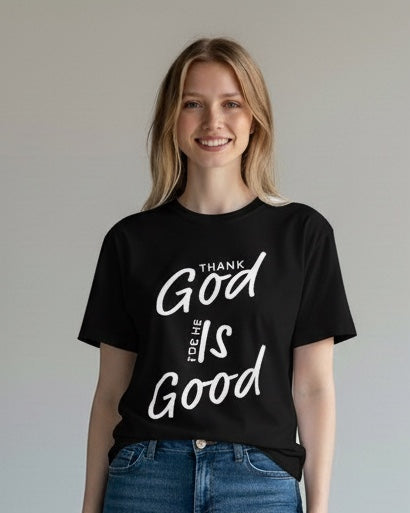 Person wearing a black t-shirt with 'Good is Good' text and blue jeans on a plain background