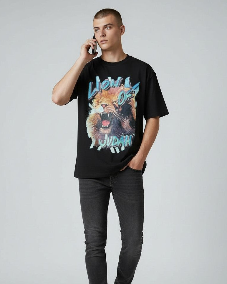 Person wearing a black christian t-shirt with a graphic design of a lion and text, on a plain background