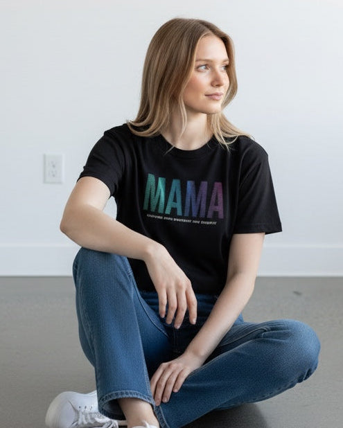 Woman sitting on the floor wearing a black t-shirt with 'MAMA' printed on it.