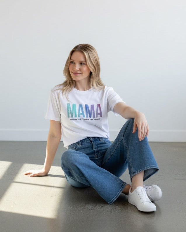 Woman sitting on the floor wearing a white t-shirt with 'MAMA' printed on it.
