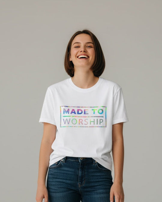 Person wearing a white t-shirt with colorful text and blue jeans on a gray background