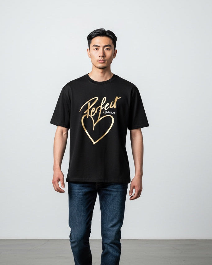 Man wearing a black t-shirt with gold text and design, standing against a plain background