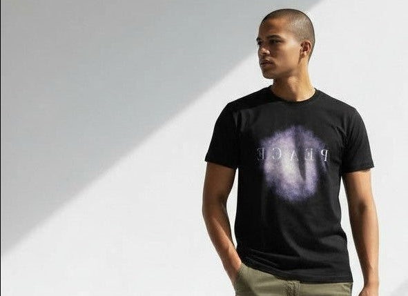 Man wearing a black t-shirt with 'PEACE' design on a white background