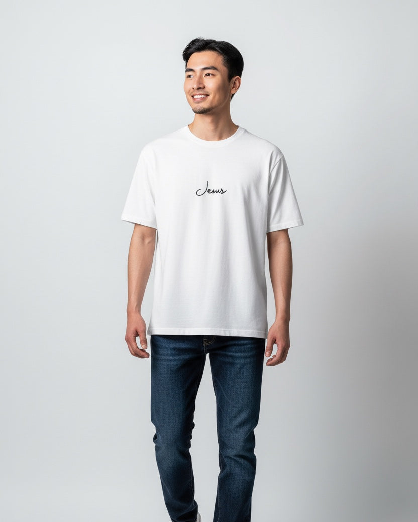 Man wearing a white t-shirt with text and dark jeans on a light gray background