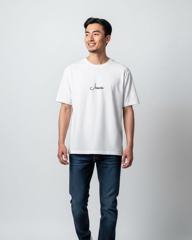 Man wearing a white t-shirt with text and dark jeans on a light gray background